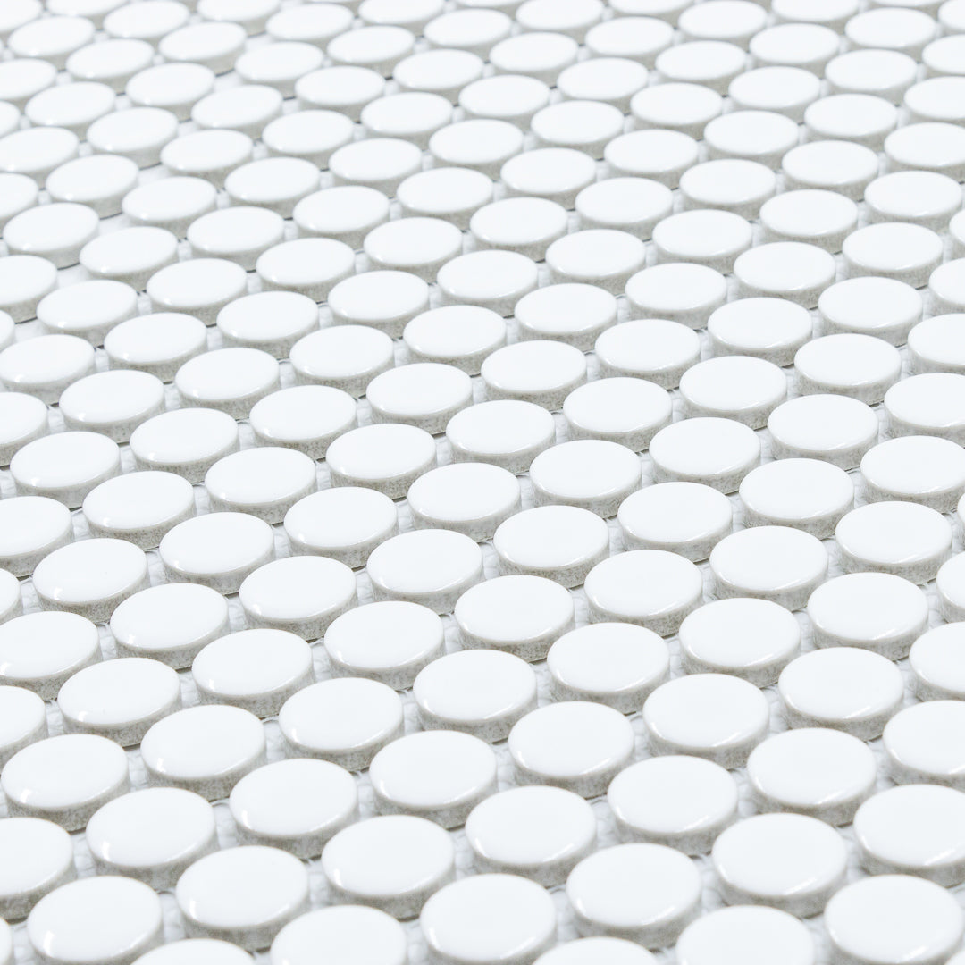 Polka-Dot Penny Round White White timeless glossy porcelain mosaic for residential and commercial spaces. This angled view shows the size and finish of the mosaic well. 