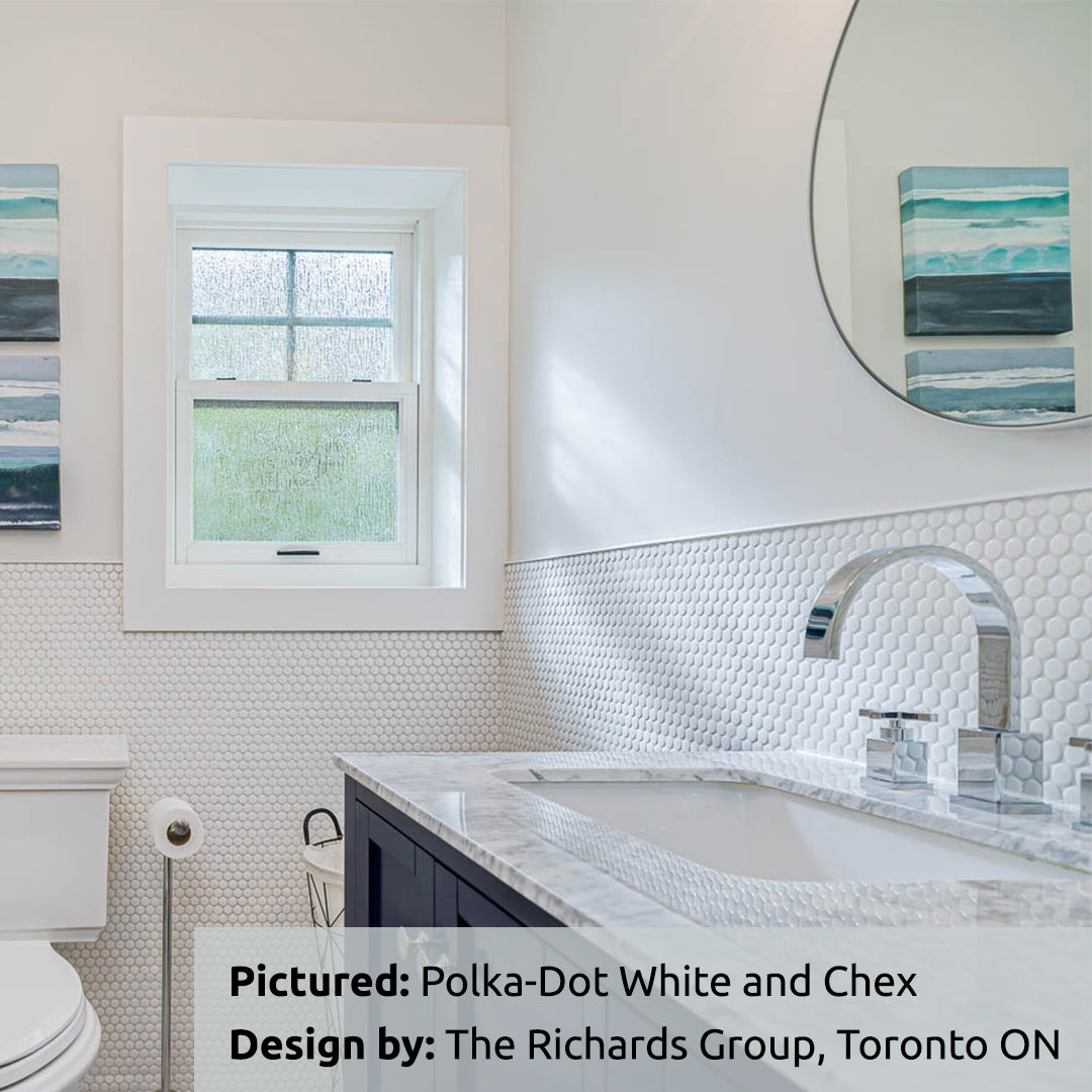 A classic and bright bathroom featuring a polka dot penny round white half wall and chair rail look. the tiles act as a backsplash on the lower half of the wall for behind the sink and around the other areas. 
