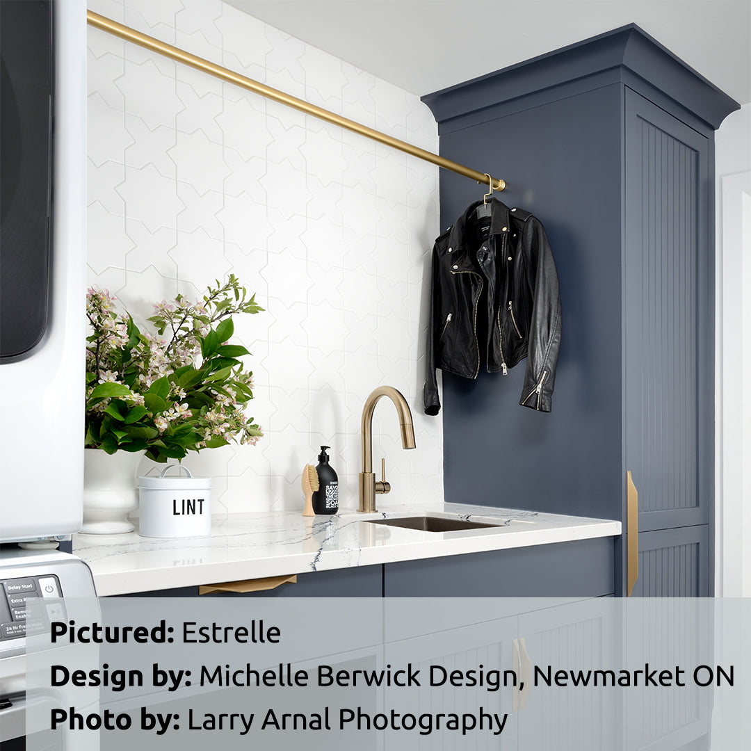 Bold blue cabinetry in a laundry room space with estrelle white star and cross shaped tiles as the backsplash. 