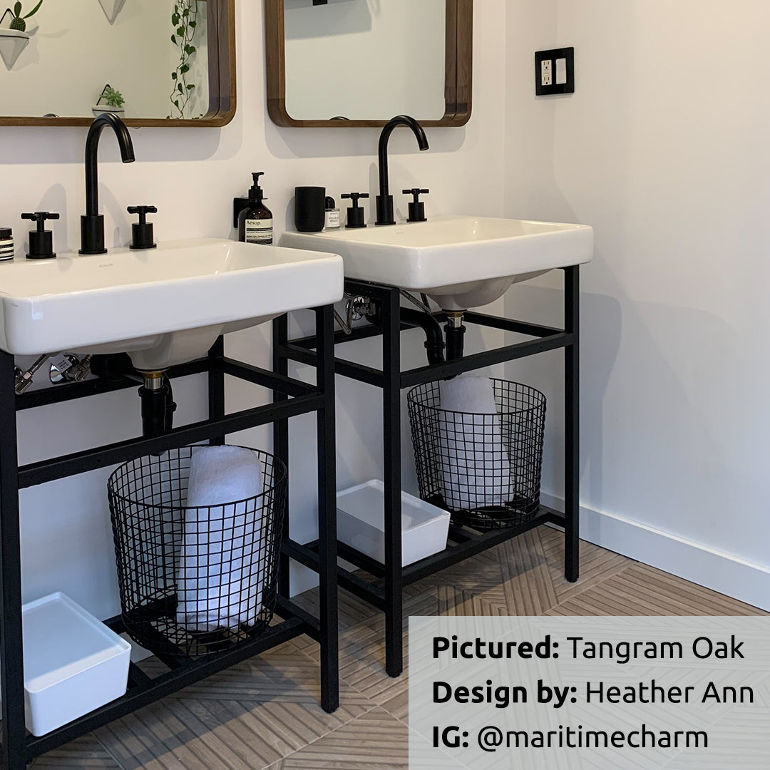 Tangram Oak Wood-Look Porcelain Tile installed on a floor under two industrial modern black bathroom vanities. Tile by TilesINspired and Realonda. Available to buy online across Canada